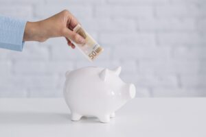 employee puts money saved from enhanced employer reporting into piggy bank