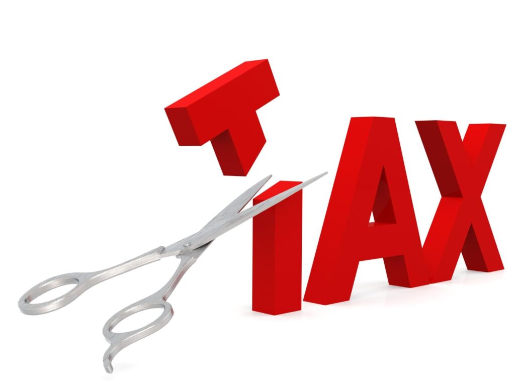 Scissors cutting the letter T in TAX